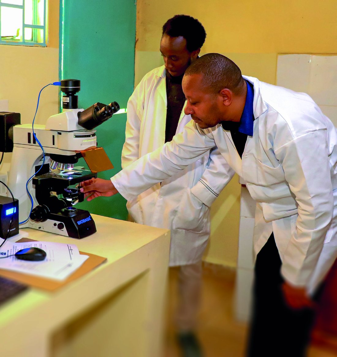 Two researchers at a microscope in a University of Embu laboratory.